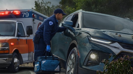 An EMT assisting a driver after a crash