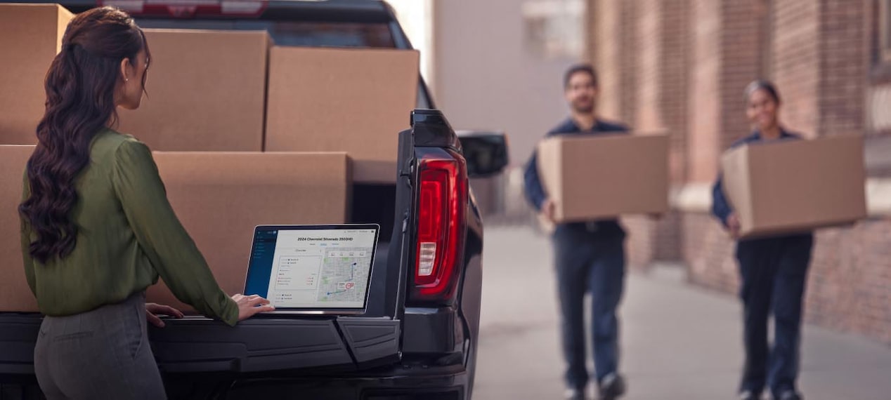 Close-up of a Person Using a Laptop on the Tailgate of a Truck