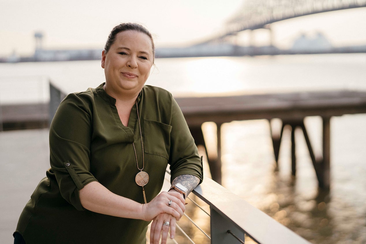 OnStar Advisor Leans on a Railing by a Body of Water