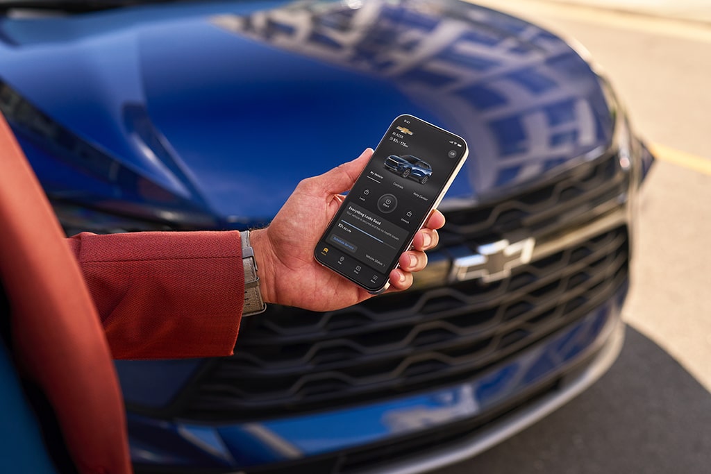 Person Using myChevrolet Mobile App in Front of Their Vehicle