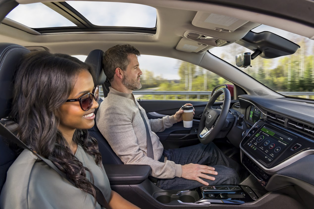 Couple Smiling While in Their Vehicle Using OnStar Super Cruise