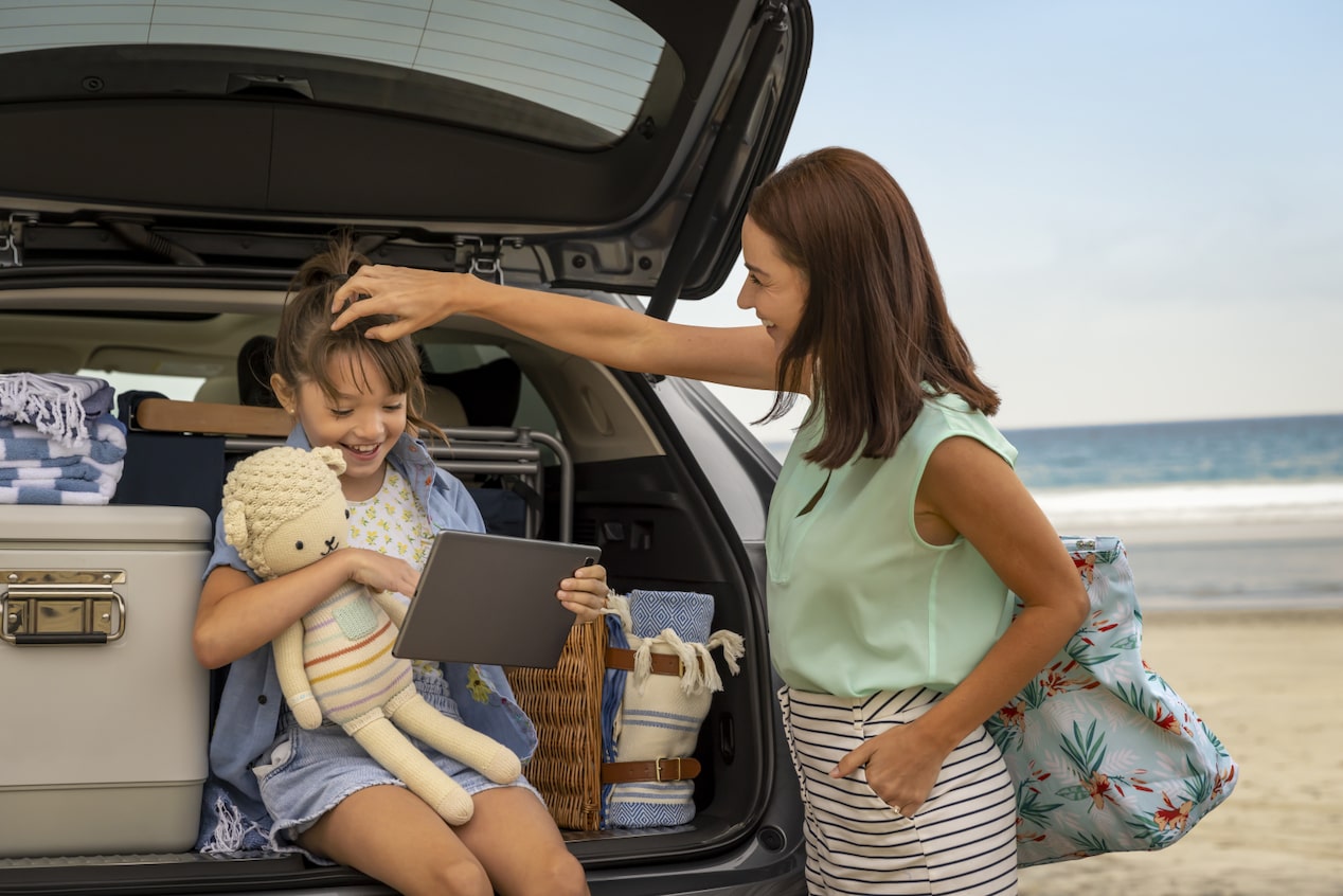 Daughter Sitting on Open Tailgate and Mother Standing Next to Her