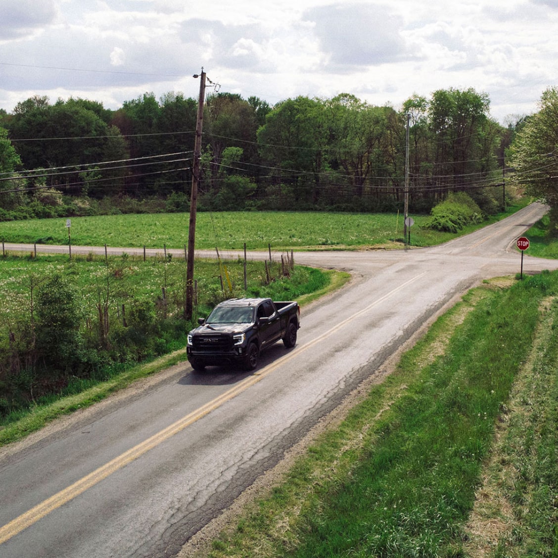 GM Truck Driving Through Small Town Roads With Green Grass