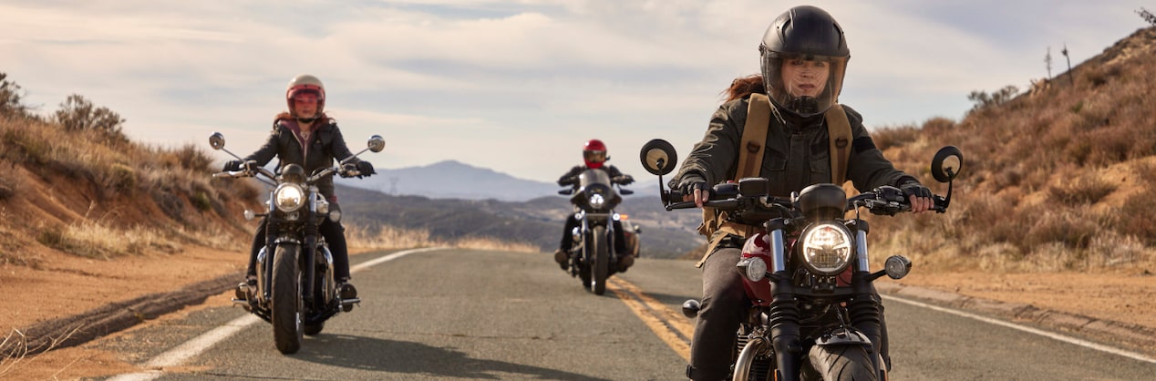 Three Motorcyclists Riding Down the Road Wearing Helmets