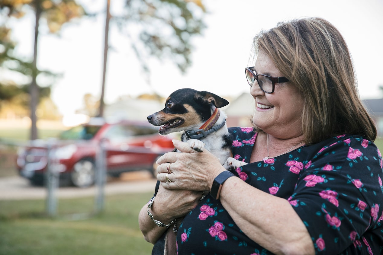 Woman Holding Her Small Dog and Smiling at Them