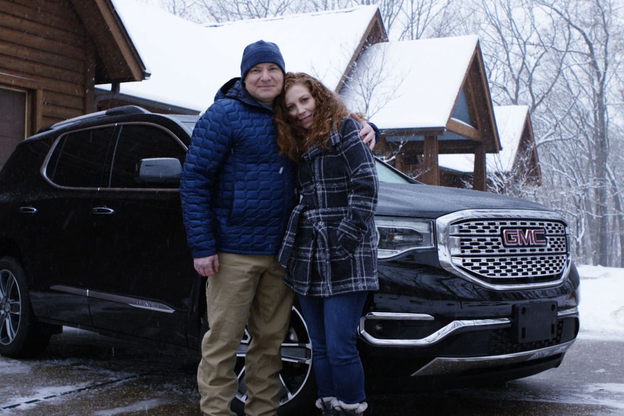 Couple Stands in Front of GMC Acadia in Winter Weather