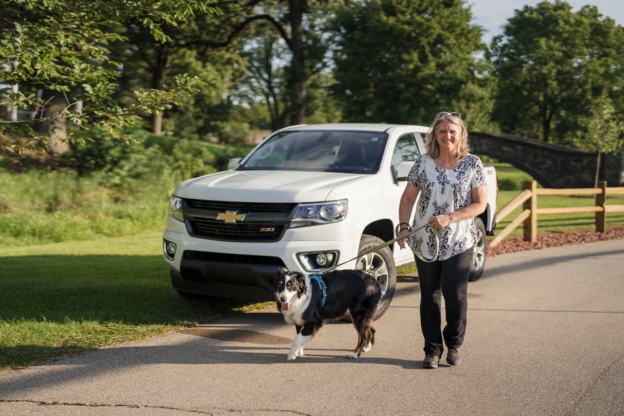 Women Walking her Dog Next to GM Vehicle