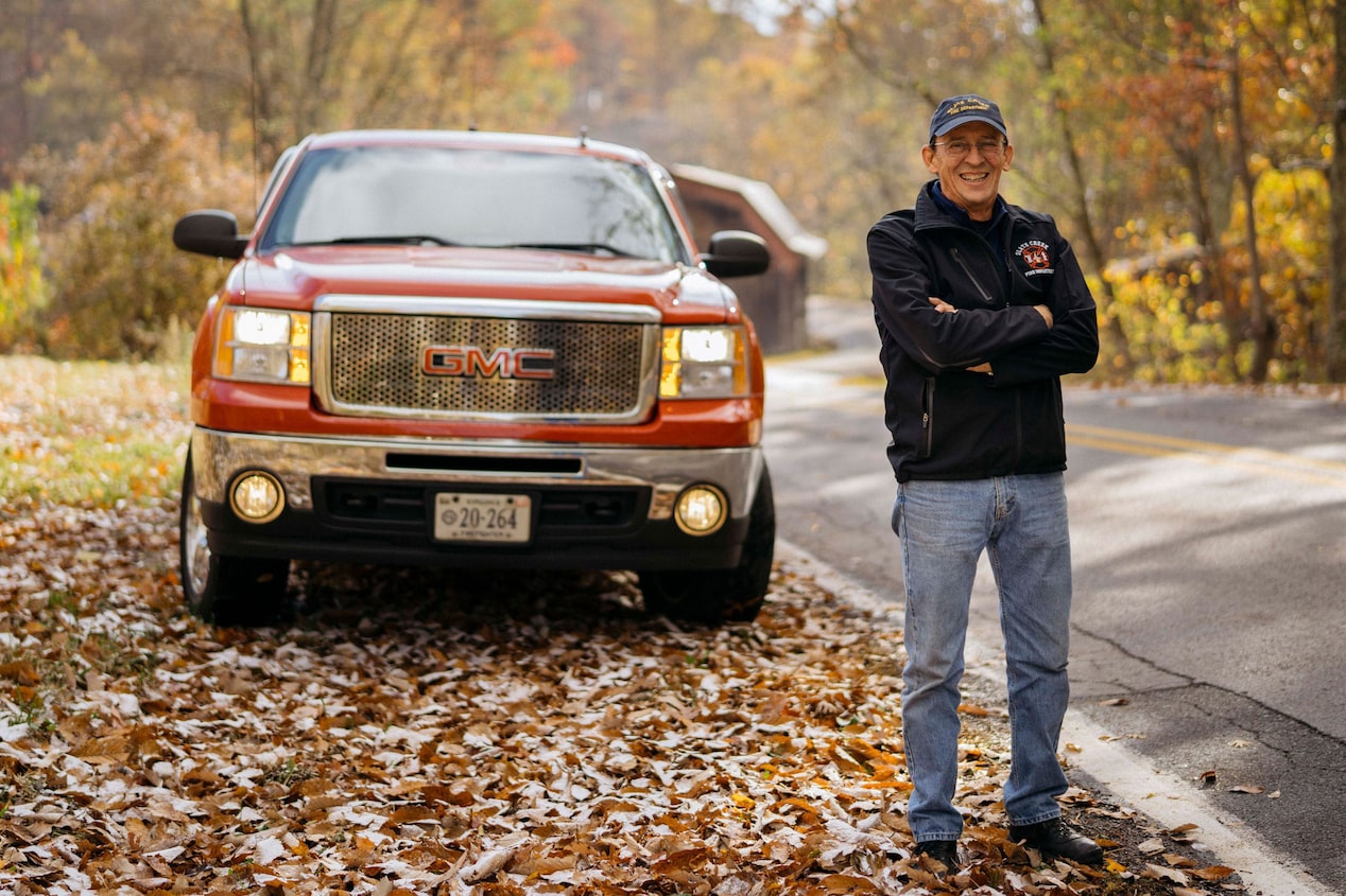 Man Standing in Front of GMC Truck on Side of the Road