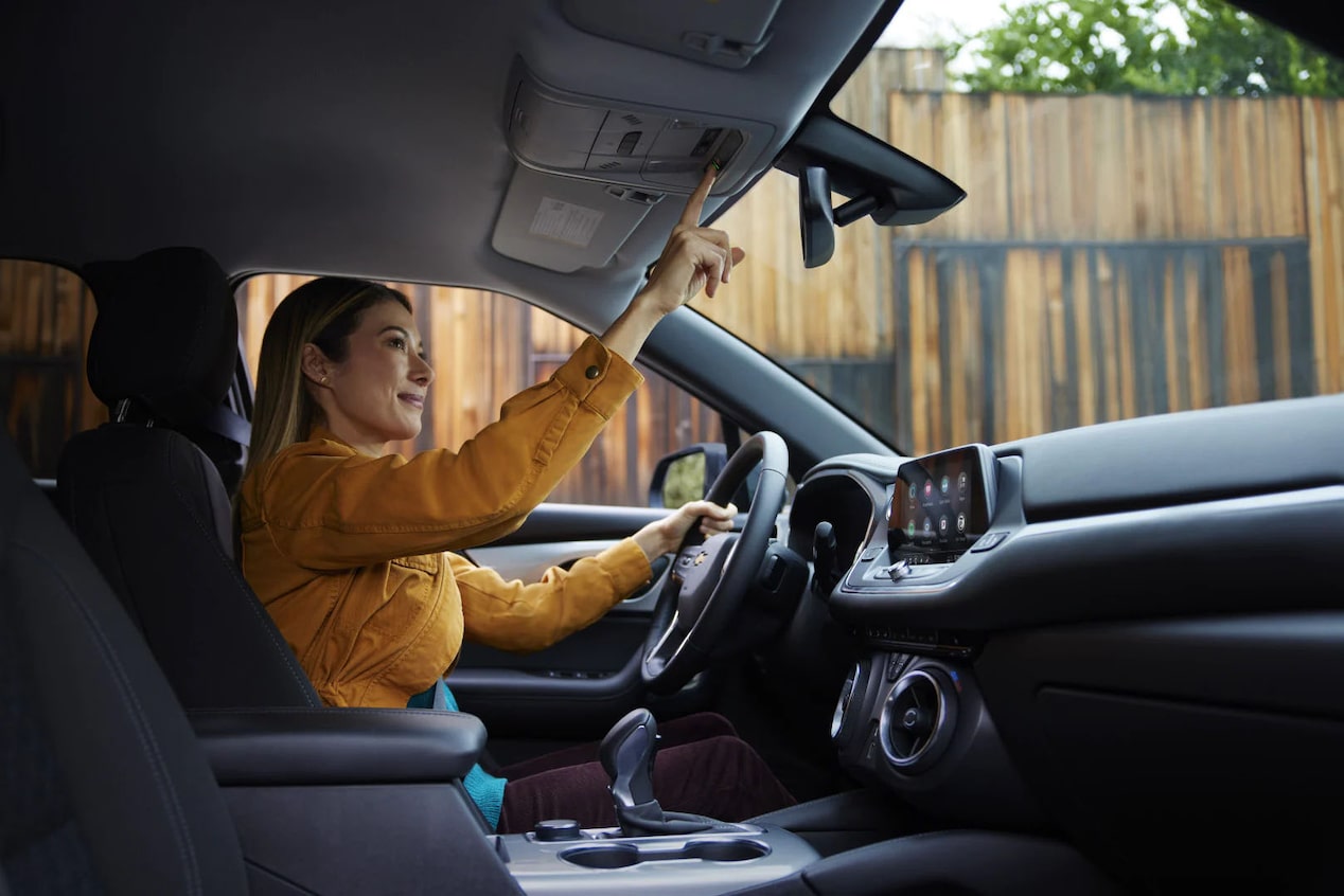 Women in Drivers Seat Pressing OnStar Button