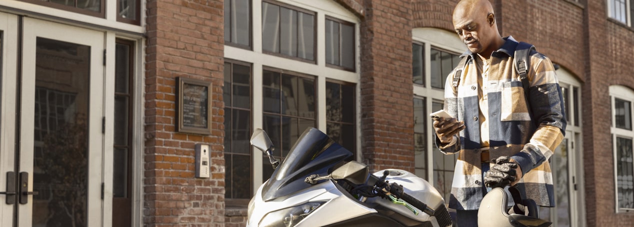 Motorcyclist Checking Phone While Taking a Break