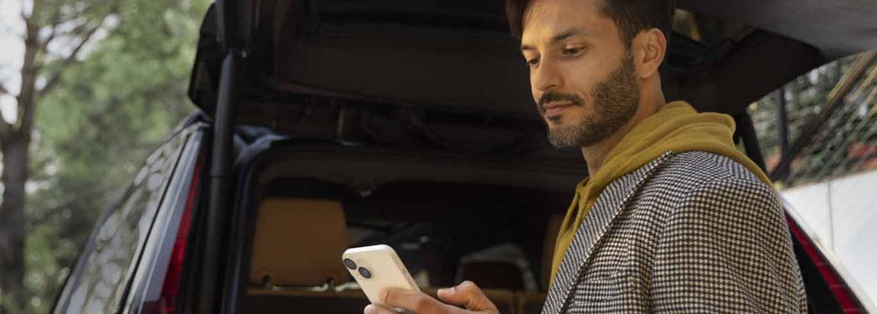 Man Using his Smartphone While Loading up his Vehicle