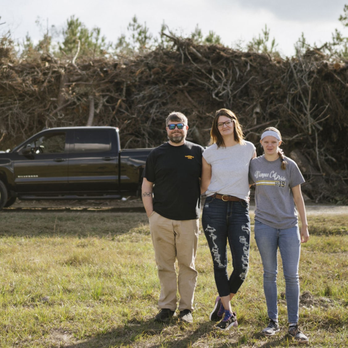 Family Standing & Smiling In Front of their GM Truck