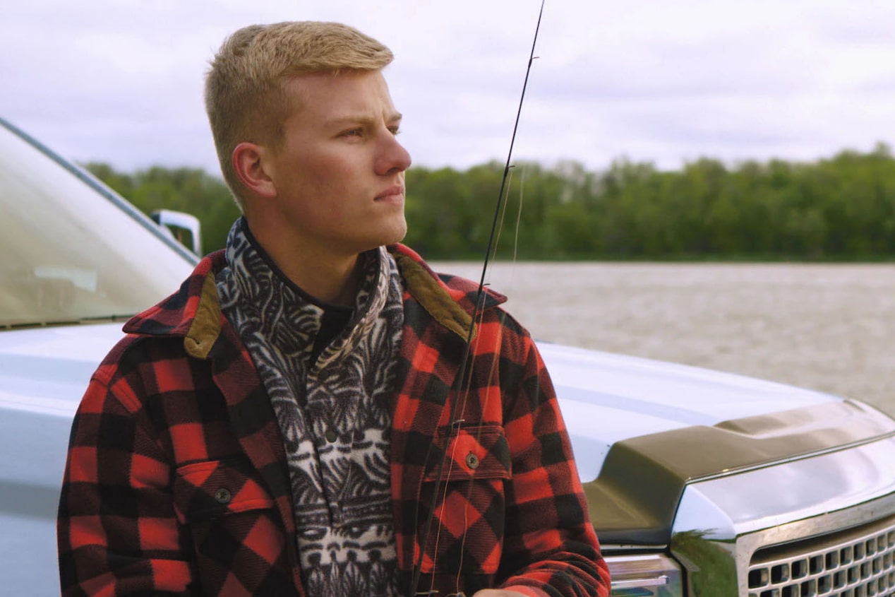 Man Leaning on Vehicle Looking out Over a Lake