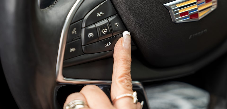 Barbara activating her Super Cruise driving assist by pressing a button on her steering wheel