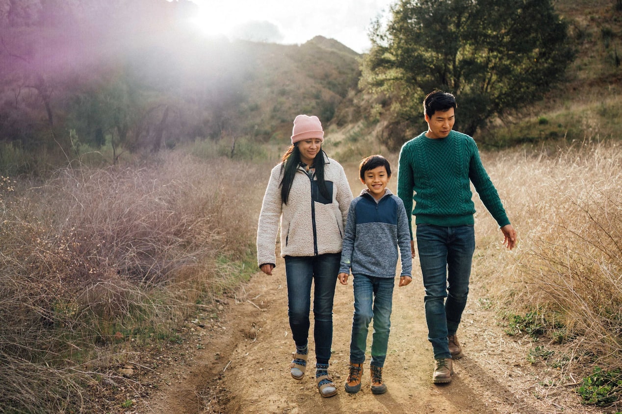 Family of Three Walking on a Trail in the Woods