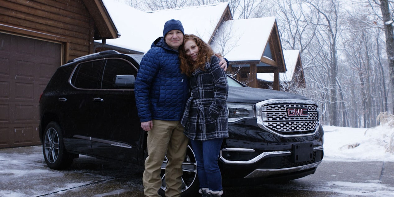 Couple Stands in Front of GMC Acadia in Winter Weather