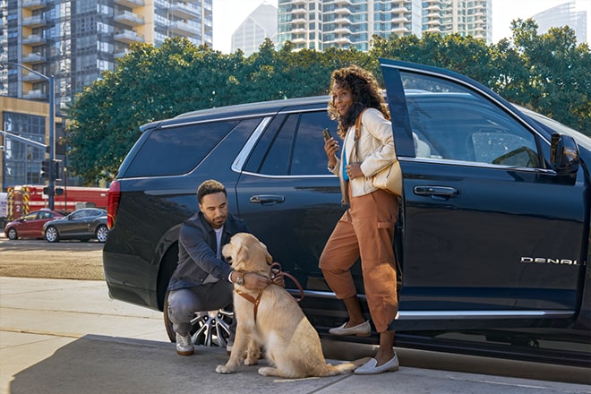 Couple Exiting Their GM Vehicle with Their Dog