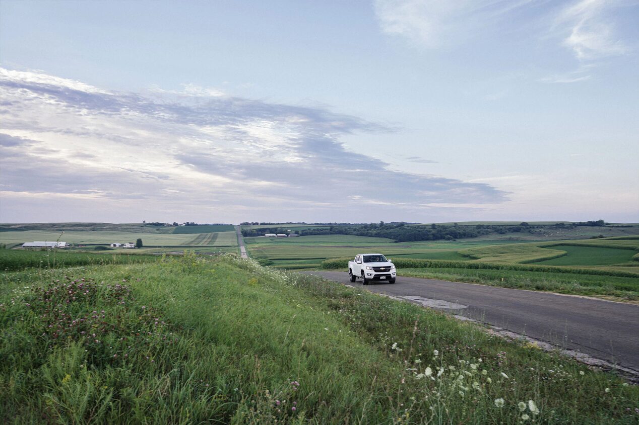 Chevy Truck Driving on a Road in an Open Landscape