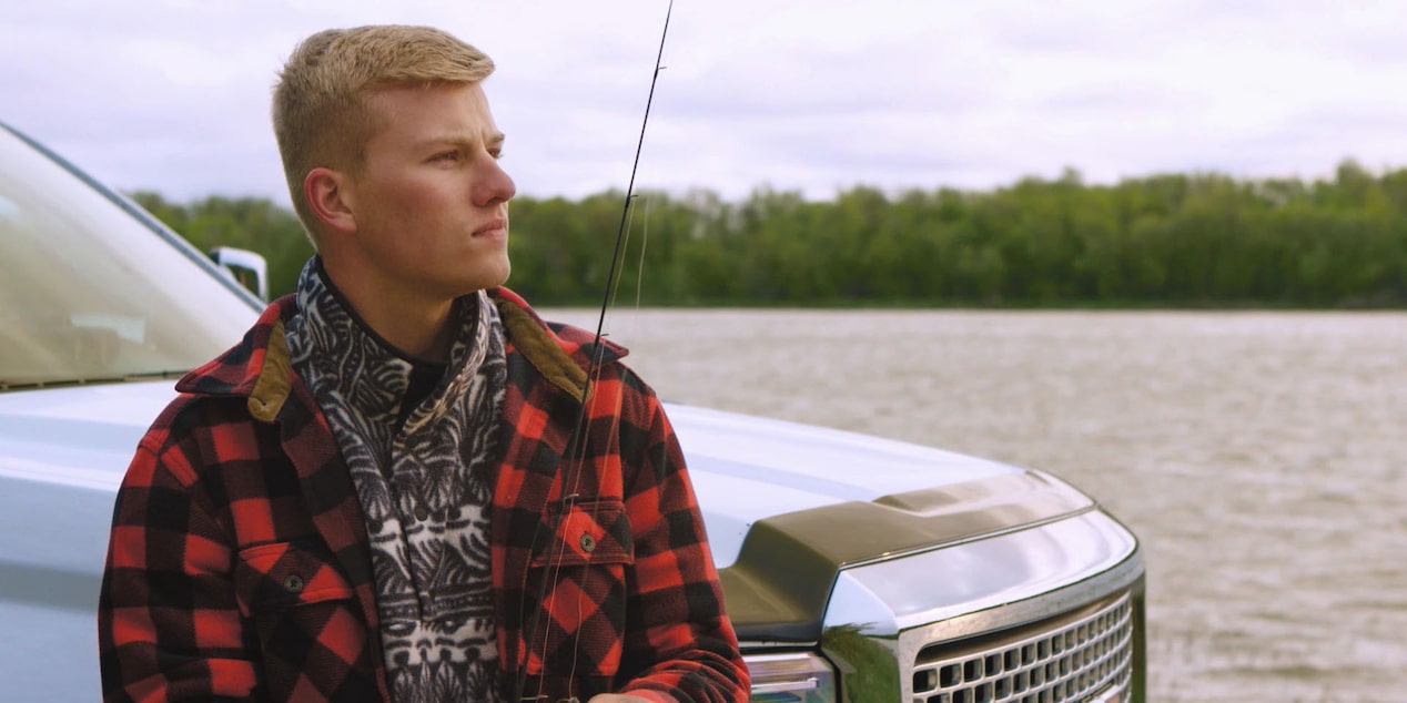 Man Standing in Front of His Truck Looking at a Lake