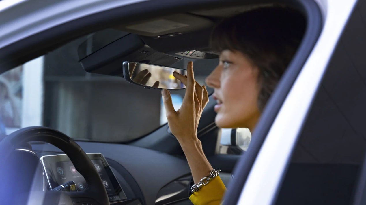 Side View of a Female Driver About to Press the OnStar Button