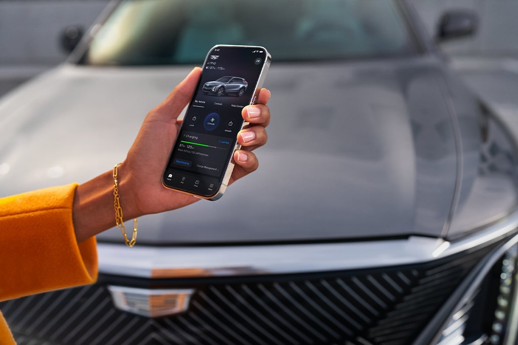 User Checking Their Phone at the Front End of a Cadillac 