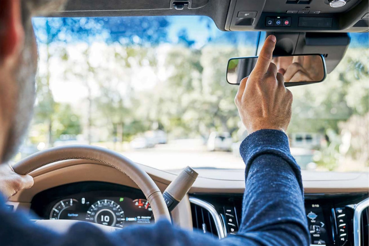 Male Driver Pressing the OnStar Button on Rearview Mirror