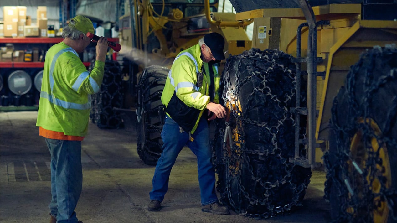 First Responders Inspecting the Wheel of a Tractor 