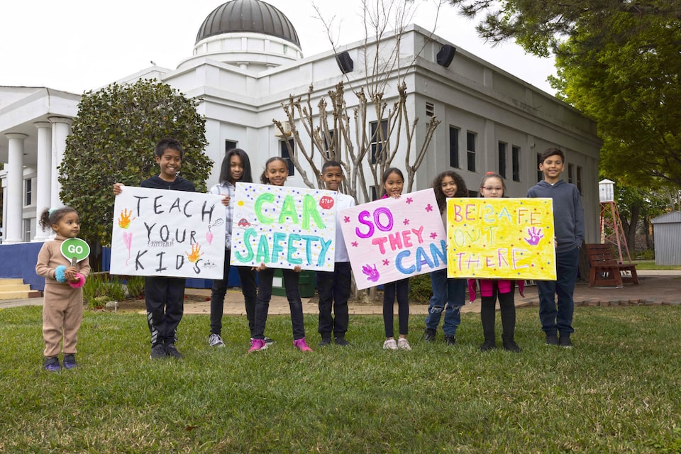 Kids Holding Home Made Signs Outside on Car Safety