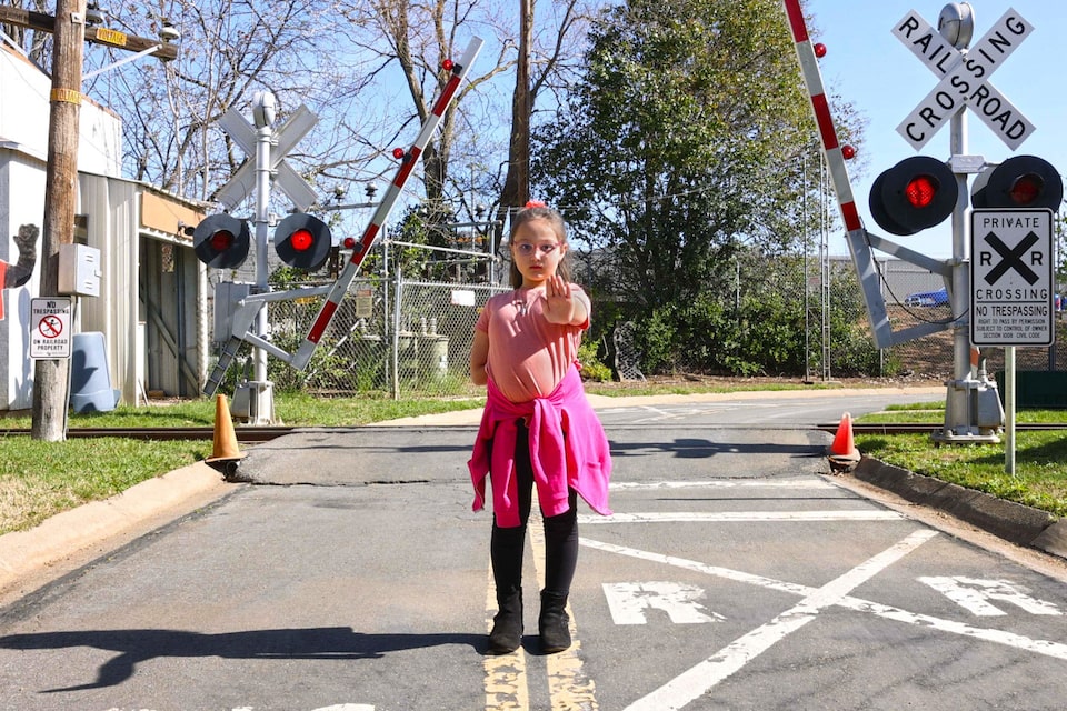 Little Girl Wearing Pink Stopped at a Train Crossing 