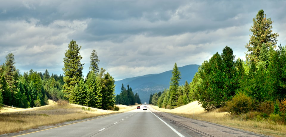 The open road of the tree-lined blue sky Interstate 90 across Montana 