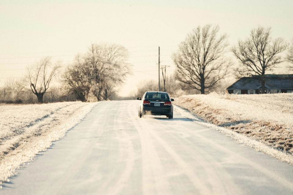 Vehicle Driving Down Snow Covered Road