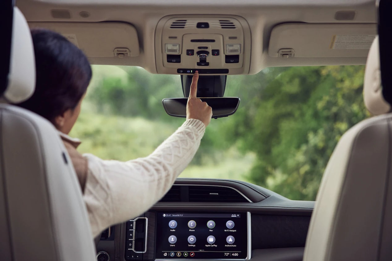 Behind View of Driver Pressing the OnStar Button